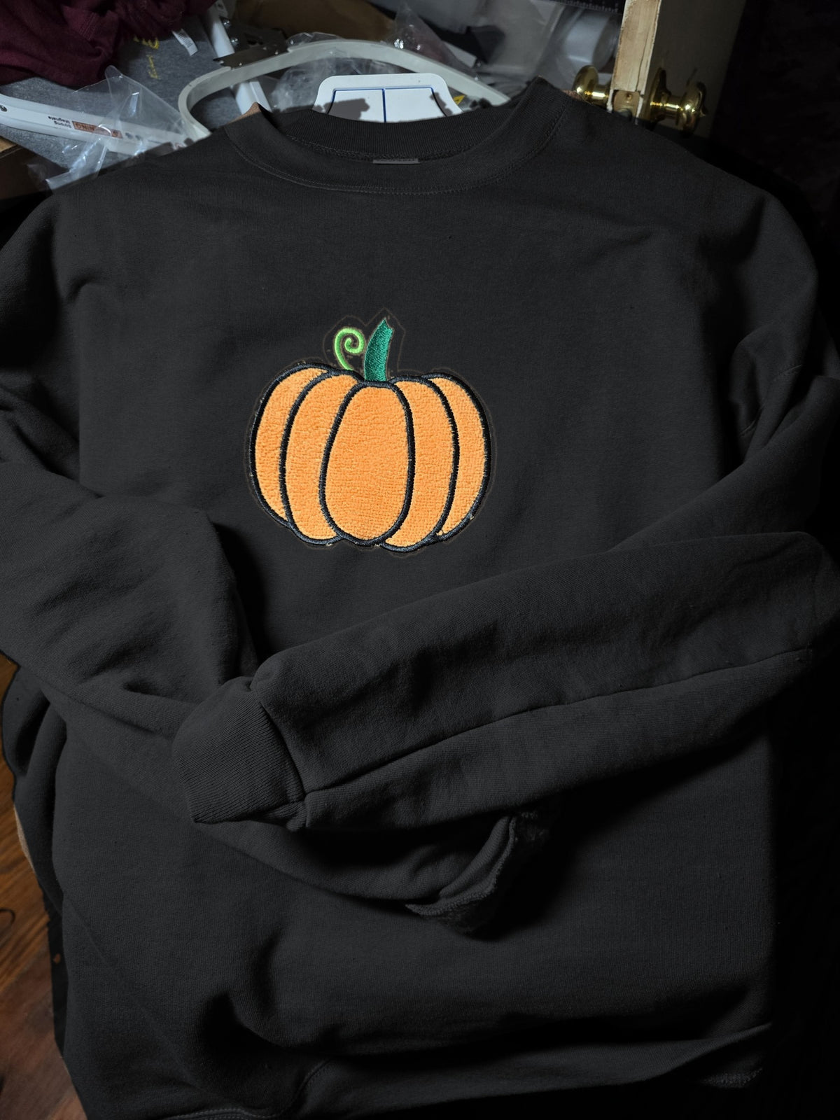 Black crewneck with fuzzy embroidered pumpkin (mockup)