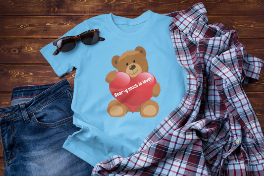 Light blue t-shirt featuring a graphic design of a brown teddy bear holding a red heart with the text Bear-y Much in Love.