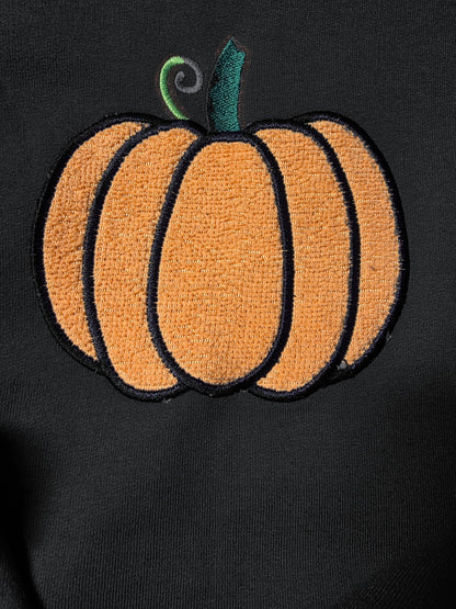 Close-up of fuzzy embroidered pumpkin on Black (mockup)